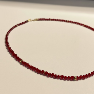 Red Carnelian Seed Bead beaded necklace on a light gray surface