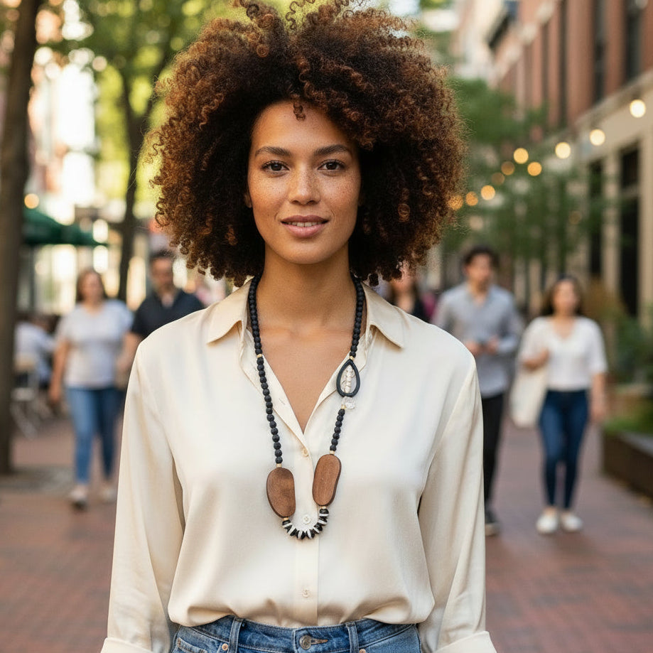 Necklace with black beads and wooden pendants on a beige background